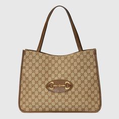 Designed with rounded edges and a soft shape, the tote bag is introduced to the Gucci Horsebit 1955 collection for Spring Summer 2020. Made from GG Supreme canvas with brown leather trim, the double-handled silhouette is finished with an organizational interior and magnetic snap closure. The collection unifies details first introduced on the original bag that inspired the line from over six decades ago with a modern spirit, highlighting the Horsebit. Part of GucciÆ’??s genetic code, the double r Gucci Gifts, Gucci Horsebit, Gucci Tote, Designer Totes, Small Tote Bag, Gucci Shoulder Bag, Original Bags, Medium Tote, Designer Shoulder Bags