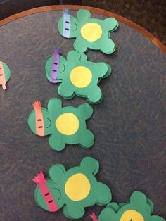 paper cut out flowers and carrots sitting on top of a wooden table with holes in the middle