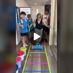 a group of people standing in a room next to a game on a wooden floor