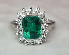 Gorgeous 14K WHITE GOLD ring Gem GREEN Colombia emerald. Center set Gem lab flux growth green Colombia emerald in emerald shape weight 1.75ct. size 8.5x7mm very nice rich vivid green color nice luster, lively ,nice cut,Sparkly emerald. side set 16 natural round diamonds total weight 0.64ct. H-VS Ring size 7.5 Retail Value $6,500 net Appraisal available Classic Emerald Cut Gemstones With Halo Setting, Green Brilliant Cut Diamond Gemstones, Green Diamond Fine Jewelry Gemstones, Formal Gia Certified Emerald Gemstones, Elegant Green Gia Certified Gemstones, Gia Certified Cluster Diamond Ring, White Gold Cluster Emerald Ring, Fine Jewelry, Emerald Gemstones With Halo Setting Fine Jewelry, Green Cluster Emerald Ring Vvs Clarity