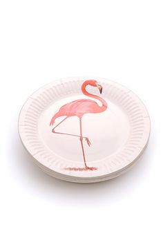 a white plate with a pink flamingo design on the front and bottom, sitting on a white surface