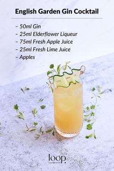 a glass filled with lemonade and garnish on top of a white counter