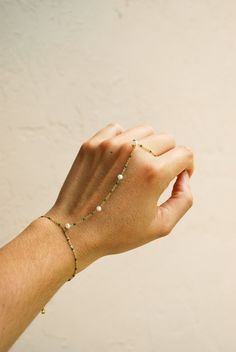 ☞ Features  ✤ Minimalist gold beaded hand chain bracelet with freshwater pearl accents and green enameled beads. ✤ All parts of the necklaces are made of a thick and sturdy 18k gold plated material along with freshwater pearls and green enamel beads. ☞ Measurements:  ✤ Bracelet Length: 6 in - Extender: 1 in - Wrist to finger length: 3.5 in  ✤ Ring sized to fit fingers US 3 - 9 in inches. ✤ Freshwater Pearls : 4 mm  ✤ Model wears bracelet at 6 inches  ✤ Gently Handmade and Polished  ☞ Shipping ✤ Adjustable Bohemian Bracelet With Delicate Chain, Adjustable Delicate May Birthstone Jewelry, 14k Gold Filled Beaded Chain Bracelets As Gift, Dainty Green Gold Plated Bracelets, Minimalist Adjustable Beaded Bracelets With Pearl Chain, Minimalist Adjustable Beaded Bracelet With Pearl Chain, Dainty Beaded Bracelets With Adjustable Chain, Dainty Pearl Bracelet With Adjustable Beaded Chain, Adjustable Dainty Green Chain Bracelet