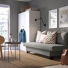 a living room with a gray couch and two pictures on the wall