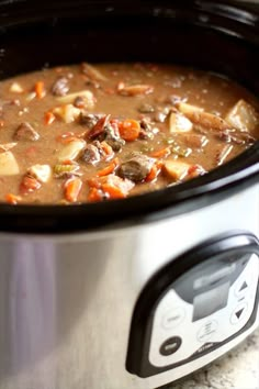 a crock pot filled with soup sitting on top of a table