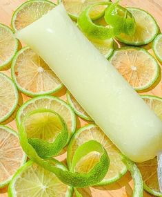 limes and sliced oranges on a cutting board next to a large piece of bread