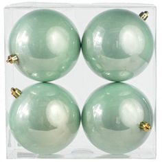 three green glass ornaments in a clear box