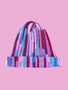 a multicolored knitted hat on a pink background