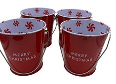 four red buckets with merry christmas designs on them