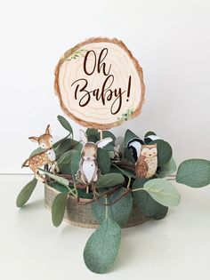 a wooden sign that says oh baby on top of some leaves and other things in front of it