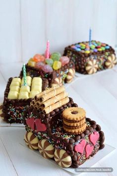 two cakes decorated with chocolate and cookies on top of each other in the shape of train tracks