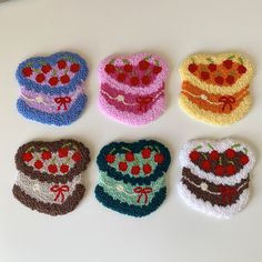 four crocheted cakes with cherries on them