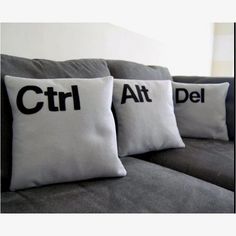 three pillows that say ctrl and atl are on the back of a couch