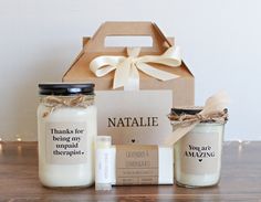 two jars with labels and some candles on a table