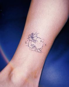 a woman's foot with a flower tattoo on the side of her left leg