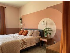 a bed room with a neatly made bed next to a window and a potted plant