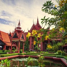 an ornate building with water and plants in the foreground