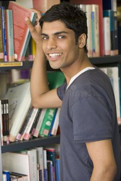 a man standing in front of a bookshelf smiling at the camera royalty images