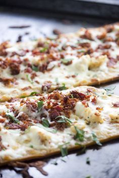 two slices of pizza sitting on top of a metal pan covered in cheese and toppings