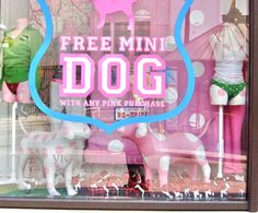 a store window with mannequins in the front and pink dog on the back