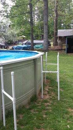 an above ground swimming pool with ladders on the side and trees in the background