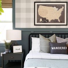 a bed room with a neatly made bed and a framed map on the wall above it