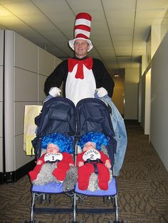 the cat in the hat is pushing two strollers with stuffed animals on them,