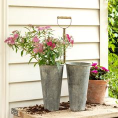 two flower pots sitting on top of a wooden table