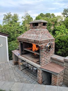 an outdoor brick pizza oven with the door open