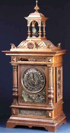 an ornate wooden clock on display against a blue background