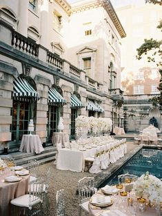 an outdoor dining area with tables and chairs set up in front of a large building