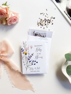 the wedding stationery is laid out next to flowers