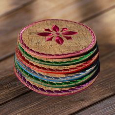 a stack of colorful coasters sitting on top of a wooden table