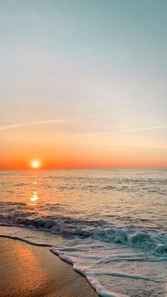 the sun is setting over the water at the beach