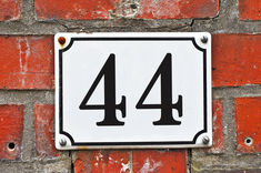 a white and black number four sign on a brick wall