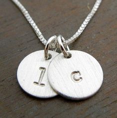 "This two charm initial necklace features two hand stamped sterling silver pendants (3/8\" wide), stamped with a featured lowercase typewriter font. The Jenna Duo features raw stamped letters (silver/no darkening and a brushed surface). You may choose another font for your letters. See last photo for samples. If you prefer a shiny, hammered or oxidized (darkened) surface, please make note in the 'notes to seller' box at checkout. TO PERSONALIZE: Please select your font and chain at checkout. Lea Hand Stamped Sterling Silver Initial Necklace With Round Pendant, Hand Stamped Sterling Silver Initial Pendant Necklace, Hand Stamped Sterling Silver Initial Necklace, Personalized Sterling Silver Necklace For Everyday, Simple Silver Hand Stamped Necklaces, Simple Silver Hand Stamped Necklace, Stamped Sterling Silver Round Disc Charm Necklace, Minimalist Stamped Sterling Silver Charm Necklaces, Sterling Silver Stamped Round Disc Charm Necklace