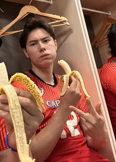 a man holding two bananas in his hands