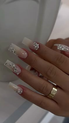 a woman's hand with some white and gold nail polish on it, next to a toilet