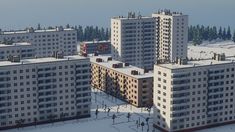 an aerial view of some very tall buildings in the middle of snow covered ground and trees