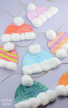 several knitted hats with pom - poms on them