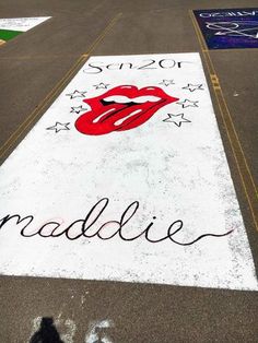 a painted street sign with the rolling stones on it's side in front of a parking lot