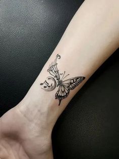 a small butterfly tattoo on the wrist