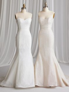 two wedding dresses on mannequins in front of white curtains