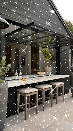 an outdoor dining area with stars on the wall and white lights hanging from the ceiling