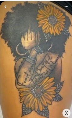 the back of a woman's stomach with sunflowers and an old tattoo