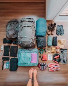 a person's feet are on the floor with many items laid out in front of them