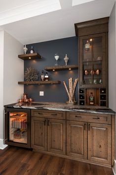 a kitchen with wooden cabinets and shelves filled with bottles, wine glasses and other items