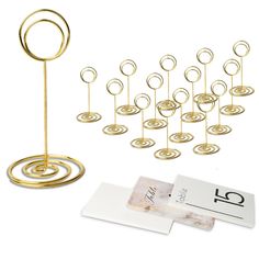 a set of twelve gold metal circles on top of each other next to a card holder