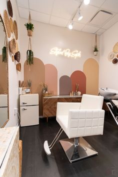 a salon with chairs, mirrors and plants on the wall above them is decorated in pastel colors