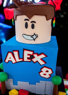 a lego man with headphones on top of a blue box that says alex 8